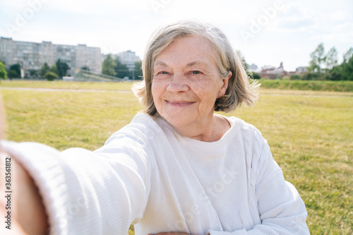 A beautiful European older woman makes aselfie. Elderly grandmother talking on video of communication