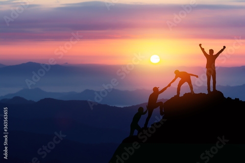 Fotografiet Teamwork friendship hiking help each other trust assistance silhouette in mountains, sunrise