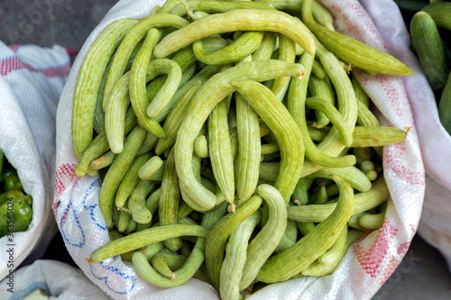 View of the Armenian cucumbers in the gunny. It is a cucumis melo var. Flexuosus is a type of long, slender fruit which tastes like a cucumber and looks somewhat like a cucumber inside. photo