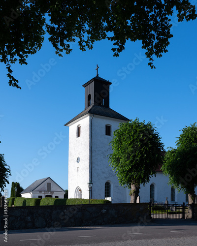 Harlösa church is a white church that stands on a hill in the Scanian landscape in southern Sweden