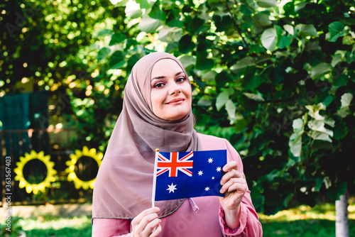 Obraz na plátně Muslim woman in hijab holds flag of Australia