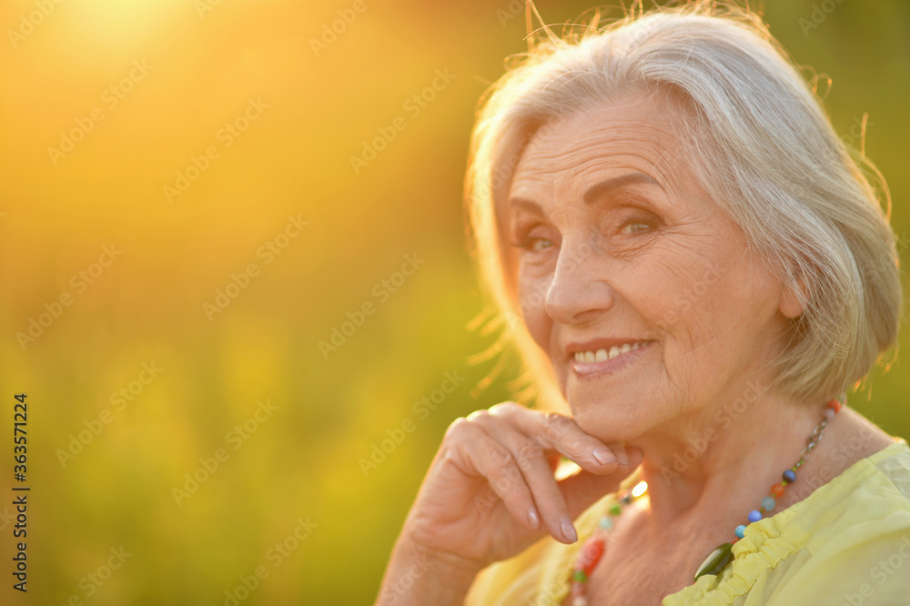 Portrait of happy senior woman smiling in park Portrait of happy senior woman smiling in park