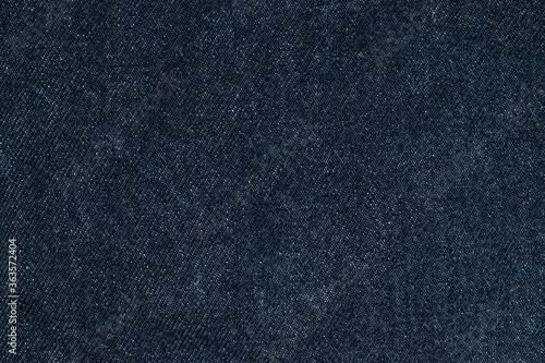 Texture details of dark blue jeans. Close up textile for background.