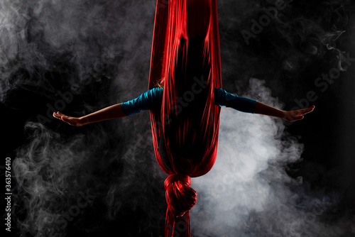 Fototapeta Naklejka Na Ścianę i Meble -  Girl gymnast hid in red aerial ribbons 