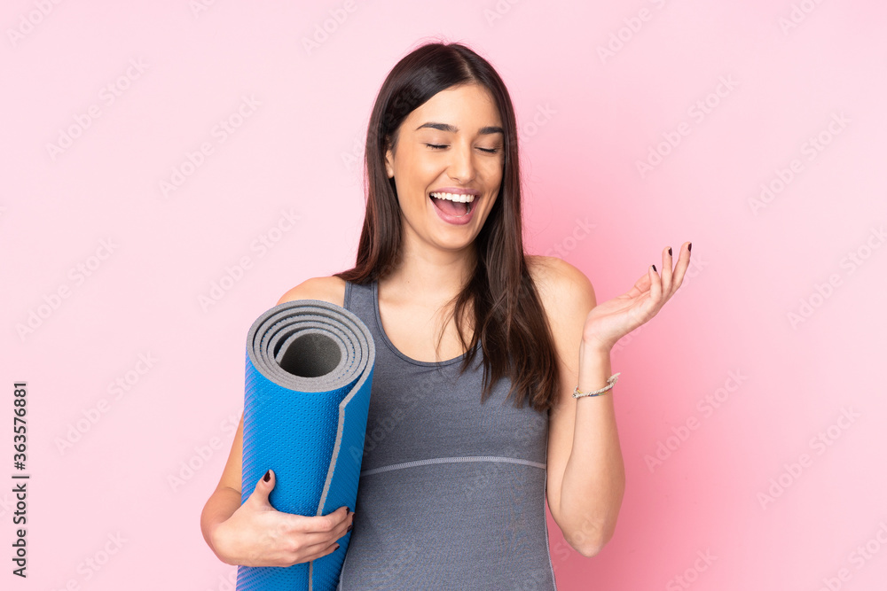 Young caucasian woman with mat isolated on pink background laughing Young caucasian woman with mat isolated on pink background laughing