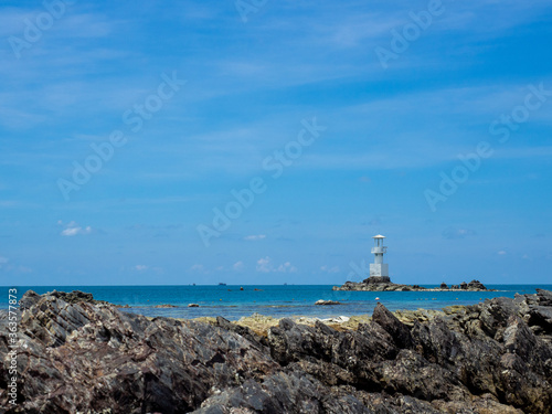 Wallpaper Mural Lighthouse in bright sunny summer day in the sea of Thailand. Rocky coast out of focus in the front. Torontodigital.ca