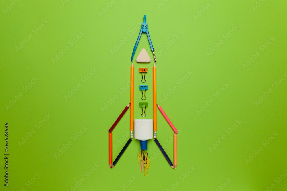 Spaceship (rocket) from stationery on green background. Child imagination, science in elementary school. (preschool) Spaceship (rocket) from stationery on green background. Child imagination, science in elementary school. (preschool)