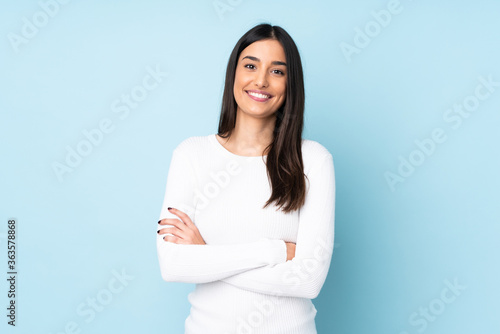 Young caucasian woman isolated on blue background keeping the arms crossed in frontal position photo