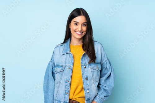Young caucasian woman isolated on blue background laughing photo