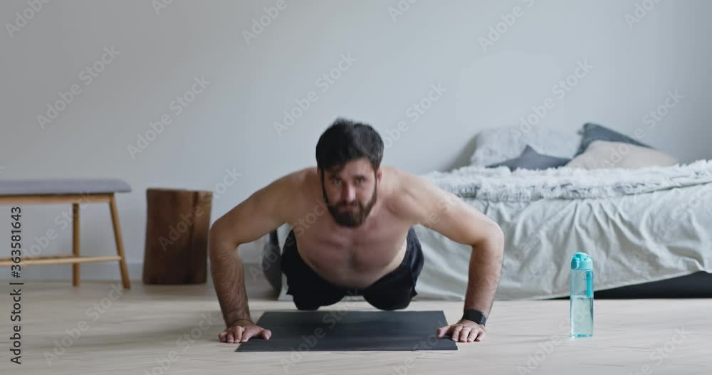 Young man with naked torso doing push ups exercise Young man with naked torso doing push ups exercise