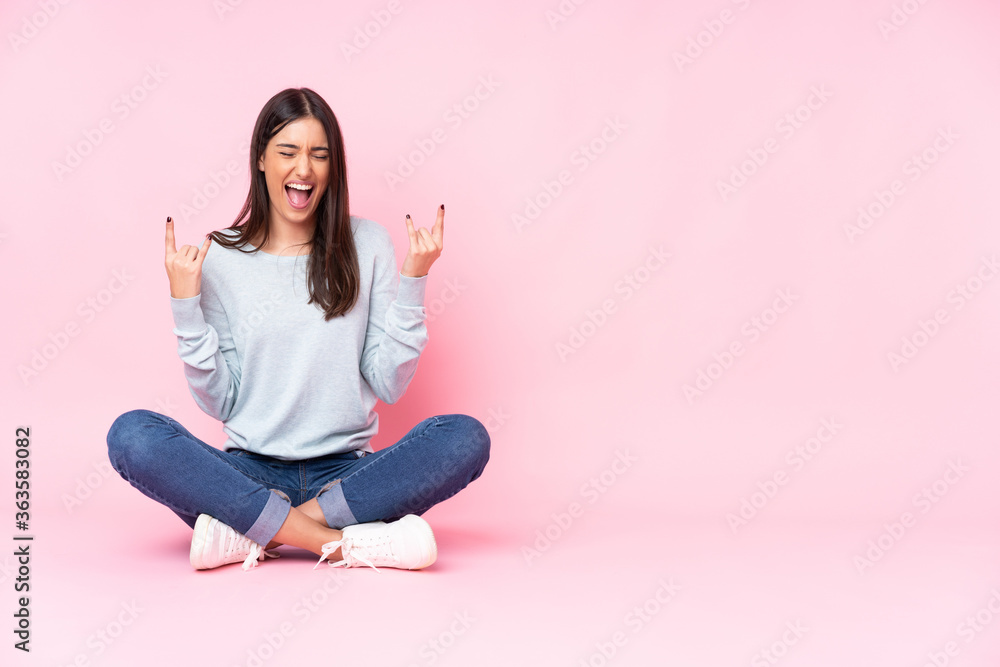 Young caucasian woman isolated on pink background making rock gesture Young caucasian woman isolated on pink background making rock gesture