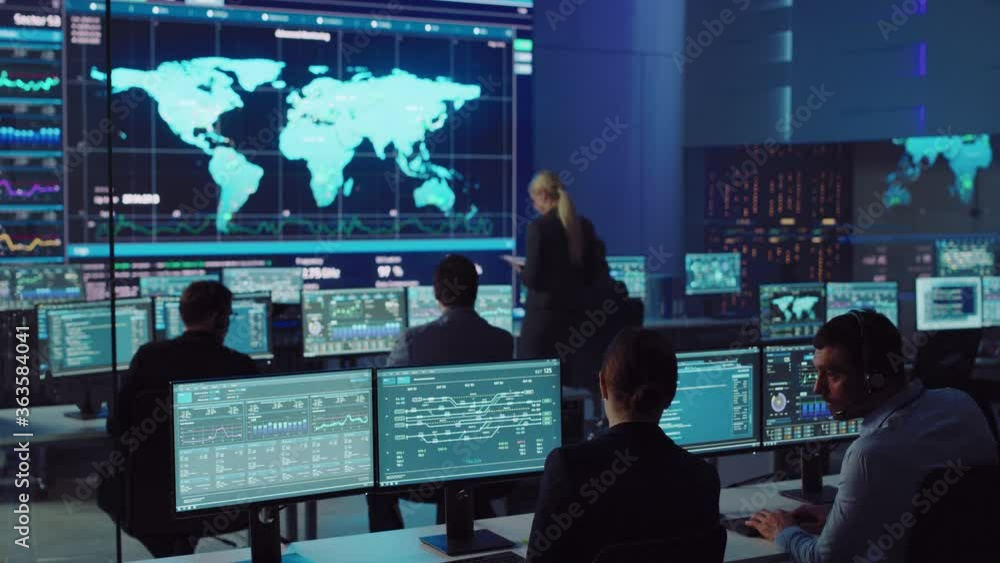 Team of Professional Computer Data Science Engineers Work on Desktops with Screens Showing Charts, Graphs, Infographics, Technical Neural Data and Statistics. Dark Control and Monitoring Room. Team of Professional Computer Data Science Engineers Work on Desktops with Screens Showing Charts, Graphs, Infographics, Technical Neural Data and Statistics. Dark Control and Monitoring Room.