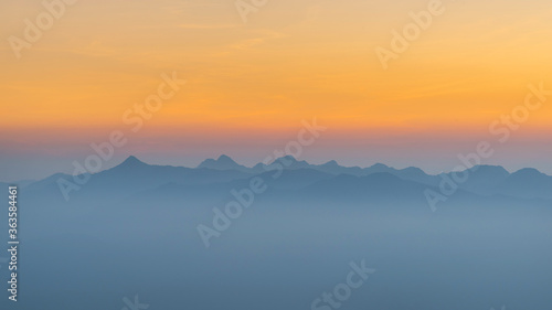 Sunset misty mountain range view from above 