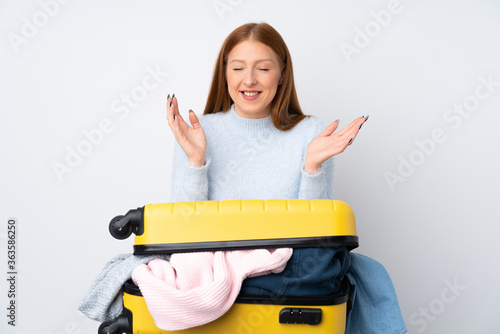 Traveler woman with a suitcase full of clothes laughing