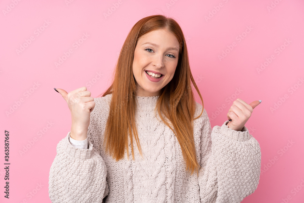 Young redhead woman over isolated pink background with thumbs up gesture and smiling Young redhead woman over isolated pink background with thumbs up gesture and smiling