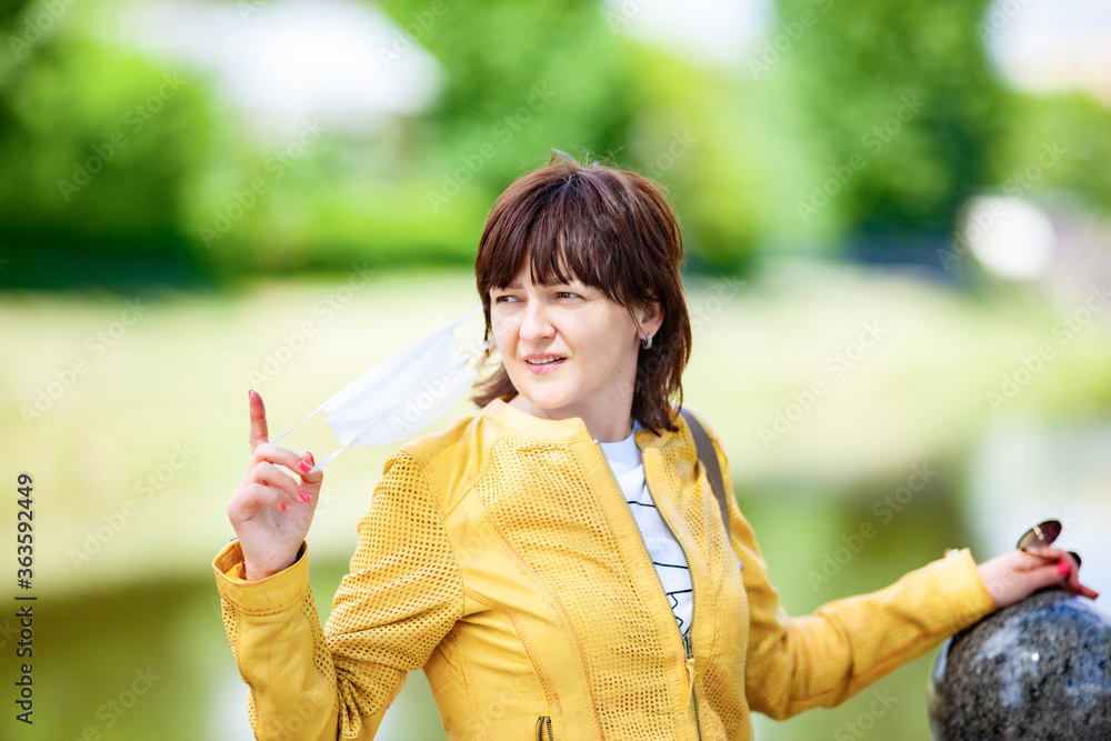 Pretty young woman looks into the distance showing a finger and looking for something on the street on a sunny warm summer day. Concept of stylish young women without age Pretty young woman looks into the distance showing a finger and looking for something on the street on a sunny warm summer day. Concept of stylish young women without age