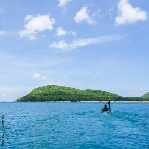 A small boat sailing to the forest island.