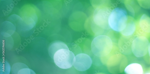 Abstract bokeh, natural green and blue background, beautifully blurred during the summer, which is a blue-green bokeh taken from the leaves on the tree and has a yellow-blue light