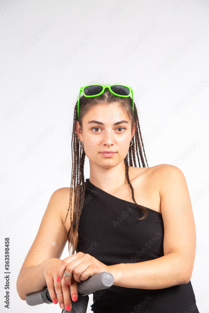 Frau mit Rasta Zöpfen und Sonnenbrille vor weißem Hintergrund Frau mit Rasta Zöpfen und Sonnenbrille vor weißem Hintergrund