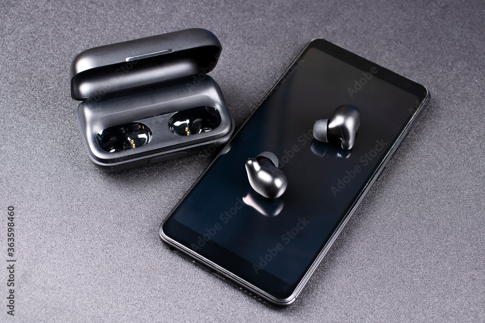 Mobile phone and wireless headphones. Mockup for design. The concept of modern technology. Wireless technology. Mobile phone and wireless headphones. Mockup for design. The concept of modern technology. Wireless technology.
