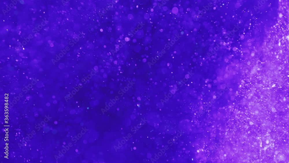 Purple particles sparkling and swirling cloud in clear fluid on dark background. Vj, tech vlogger and abstract motion art concepts. Purple particles sparkling and swirling cloud in clear fluid on dark background. Vj, tech vlogger and abstract motion art concepts.