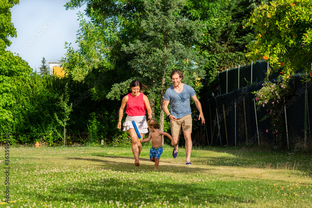 family playing happily with their little son in the garden. family playing happily with their little son in the garden.