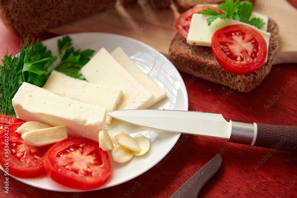 healthy food - fresh bread and feta cheese on a wooden background, tomatoes, greens and vegetables healthy food - fresh bread and feta cheese on a wooden background, tomatoes, greens and vegetables