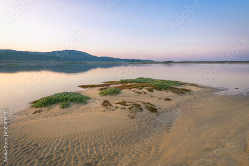Sandbar with ripples caused by water photo