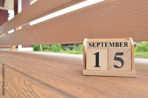 September 15, Number cube with wooden balcony background.