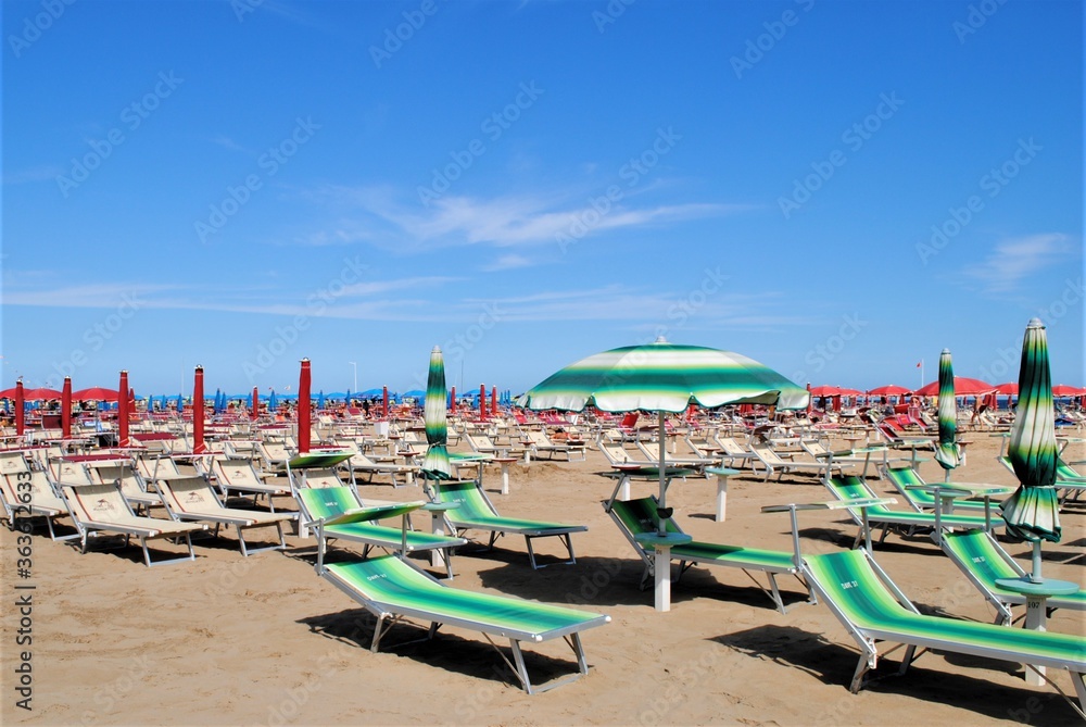 Colorful chairs in a sandy beach in Rimini, Italy. Relax vacations in an italian beach