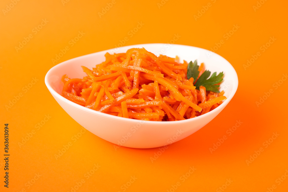 Bowl with carrot salad on orange background, close up Bowl with carrot salad on orange background, close up