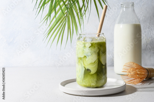 Tableau sur toile Iced Green matcha tea mixed with ice cube and milk in latte glass on white