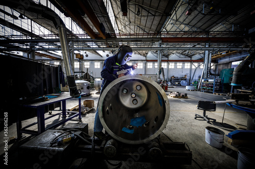Welder at work in industrial environment