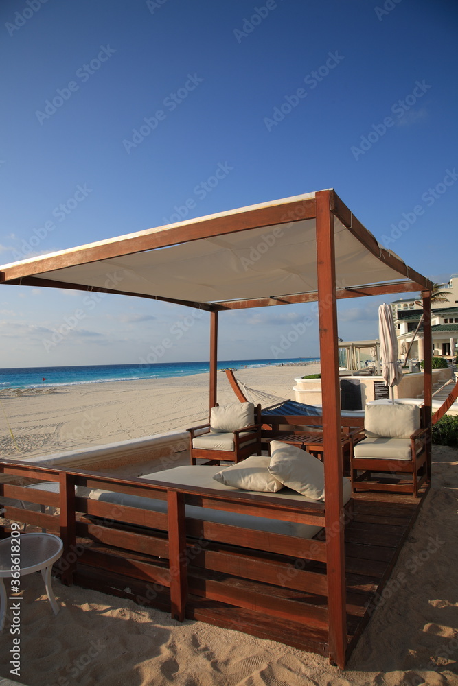View of Caribbean beach with seaside resort and wooden pavilion at Cancun, Mexico