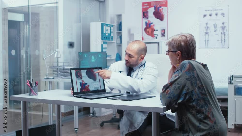 Young male doctor explaining possible heart disease to elderly retired ...