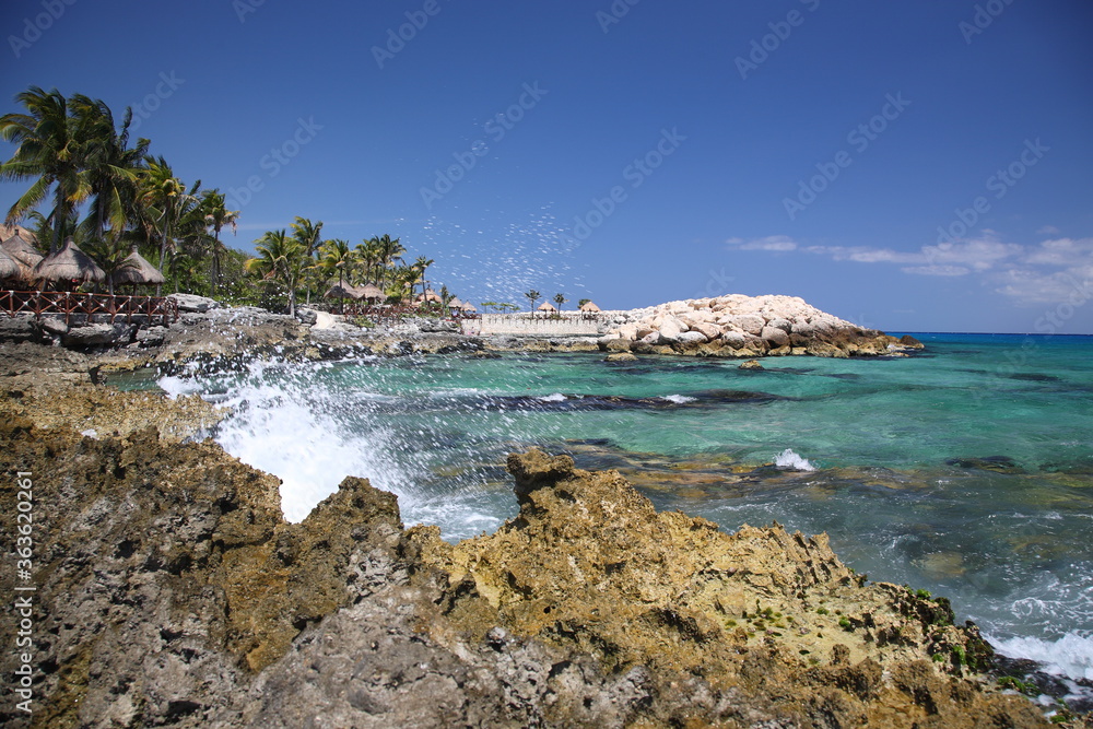 A scenic view of nature park  Xcaret with rocks and ocean under blue sky in playa del carmen Mexico