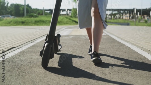 CLose up of female legs and the electric kick scooter