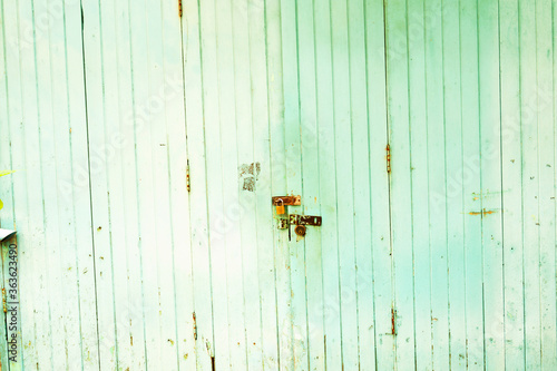 Old wooden door wall. Painted with white paint, cracks and damage on the textured surface