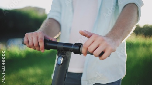 Close up of male hands and an electric scooter
