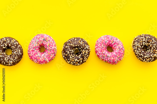 Fototapeta Naklejka Na Ścianę i Meble -  Colorful donuts pattern top view. Strawberry and chocolate donuts