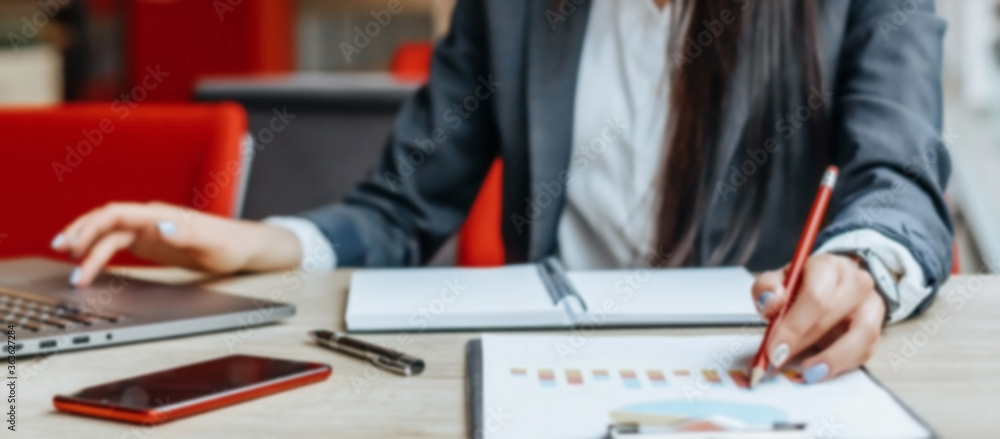 Business woman checks charts and refreshes financial progress. The girl analyzes the business model in the workplace. Business woman checks charts and refreshes financial progress. The girl analyzes the business model in the workplace.