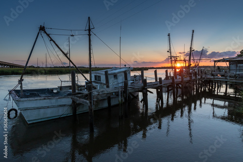 The sun setting on the shrimp boat docks along the Darien River at the port town of Darien photo