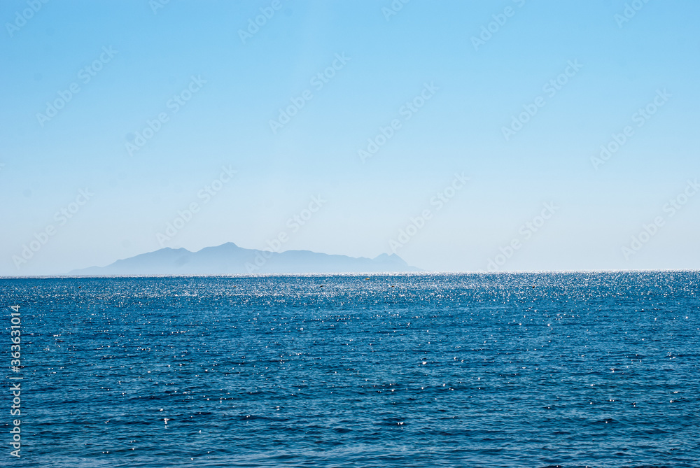 sea on the horizon island against a clear blue sky sea on the horizon island against a clear blue sky