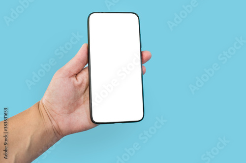 Modern smartphone with blank screen in female hand isolated on blue background mock up.