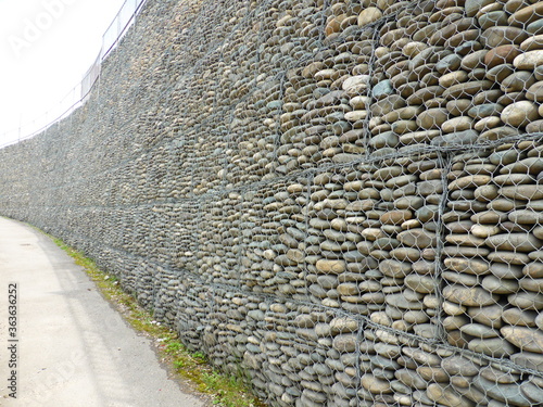Wall of stones under the grid - gabion