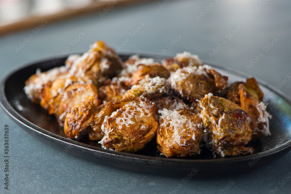 Brussels sprouts shaved and served with crispy bacon and seasoned with olive oil and seasoned with salt and pepper and fresh herbs. Classic American Restaurant appetizer favorite. 