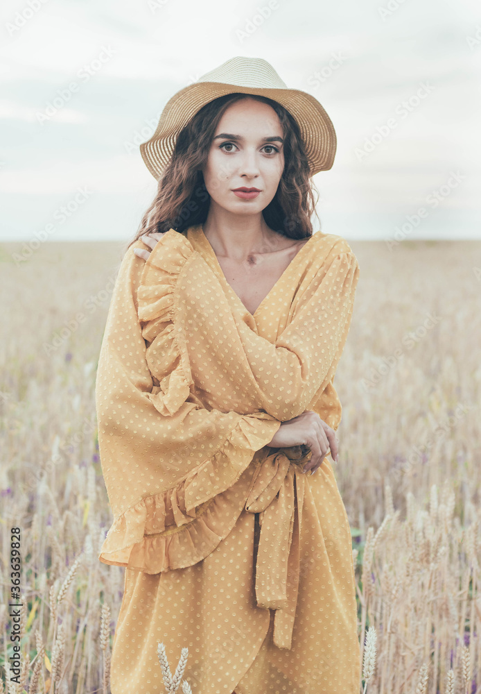 Φωτογραφία Portrait of a girl of model appearance on the field in a hat and dress
