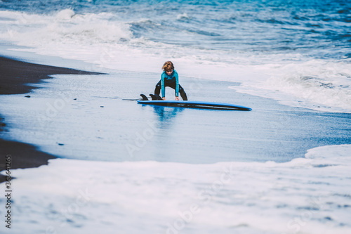 A young blonde boy enjoying a funny surf day in the beach in holidays