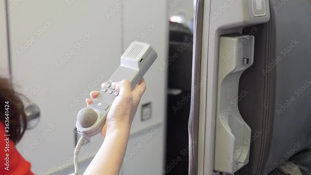 female cabin crew pick up interphone and make emergency call in flight. Aircraft equipment. female cabin crew pick up interphone and make emergency call in flight. Aircraft equipment.