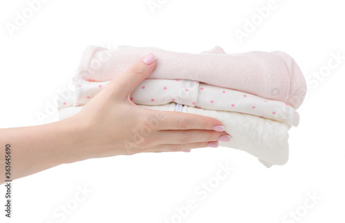 Hand holding stack folded baby clothes on white background isolation